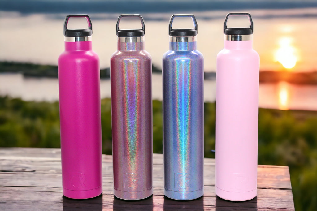 "Image displaying a 26 oz. RTIC water bottle available in various color options including flamingo pink, very berry, shimmering pink mermaid, and shimmering blue pacific. The bottle is shown against a sunset background, accentuating its vibrant colors and sleek design against the warm hues of the setting sun."