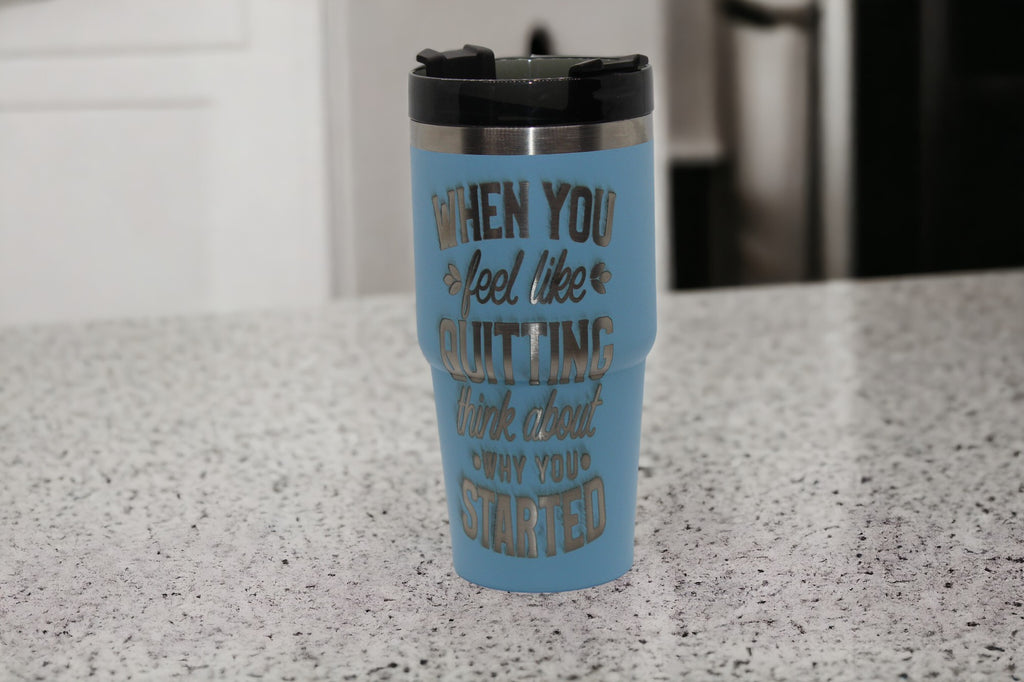 A light blue travel mug with handle that is laser engraved with "When you feel like quitting, thank about why you started".
